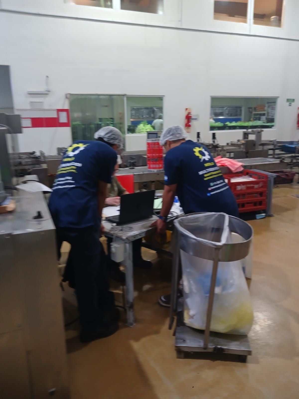 Trabajadores con camisas azul marino clasifican artículos en una estación de empaquetado de un almacén
