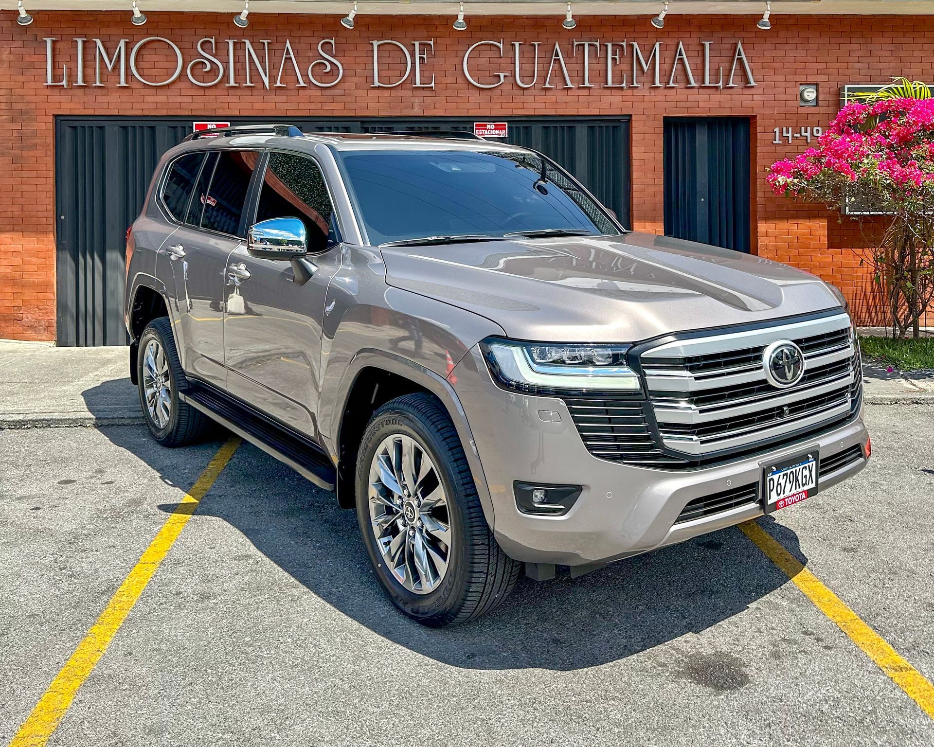 SUV plateado estacionado frente a un edificio con el letrero “Limosinas de Guatemala”.