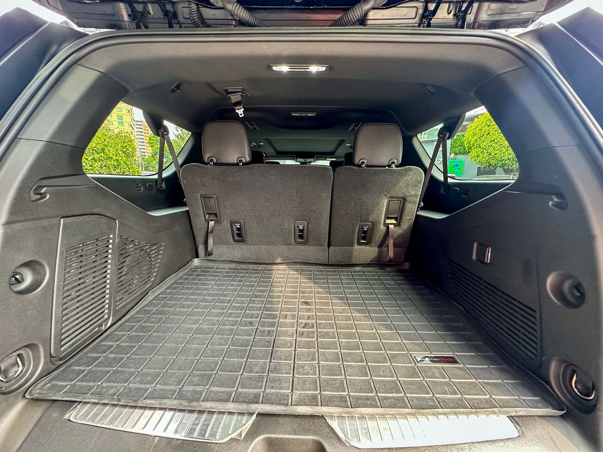 Zona de carga vacía del SUV con los asientos traseros plegados y una alfombrilla de goma en el suelo.
