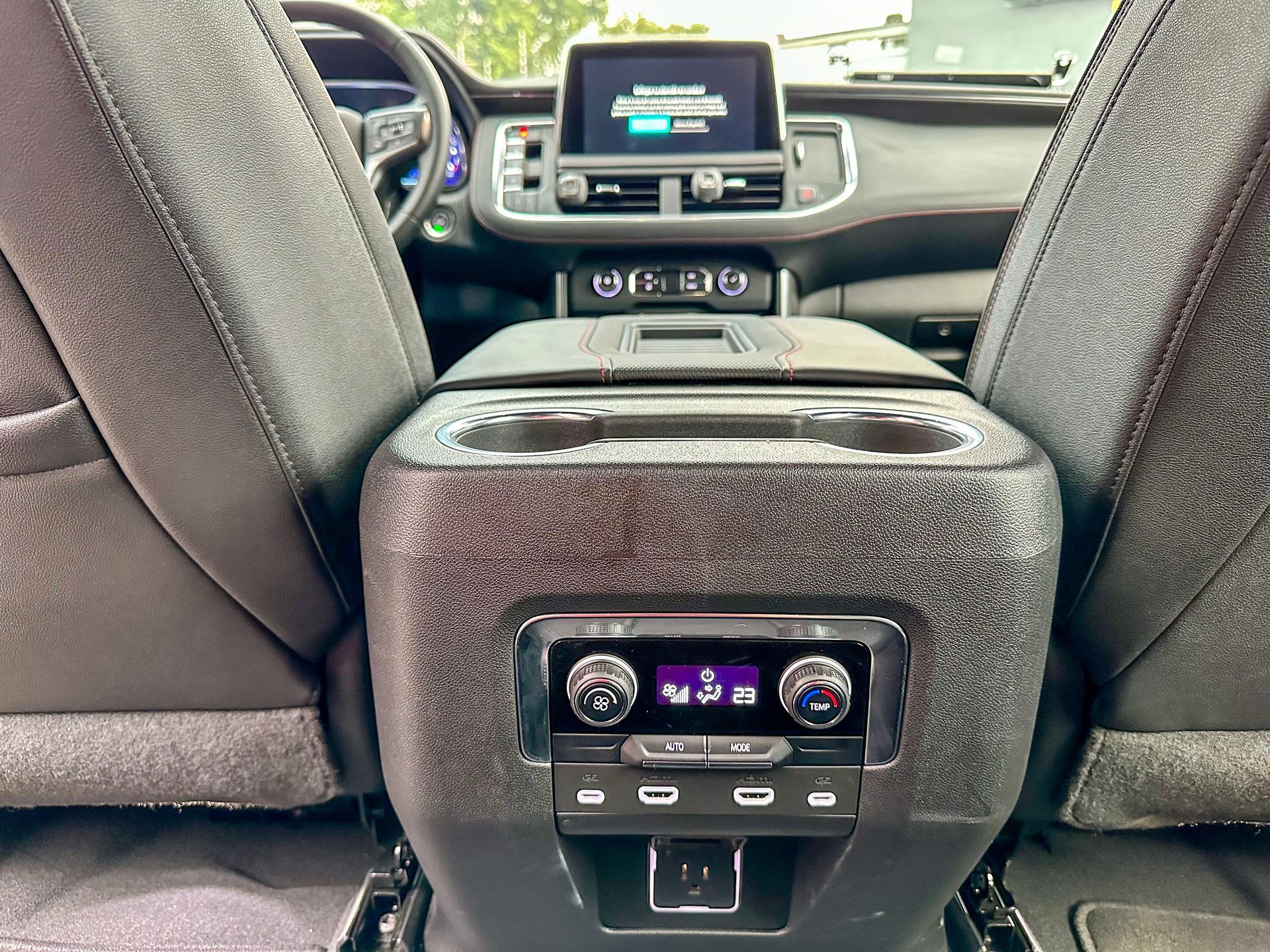 Interior del coche con controles de climatización traseros y pantalla en el salpicadero delantero