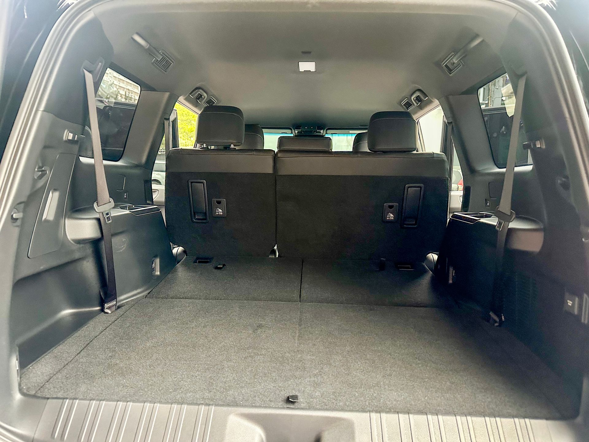 Zona de carga vacía del SUV con los asientos traseros abatidos, dejando ver un suelo de carga plano y alfombrado.