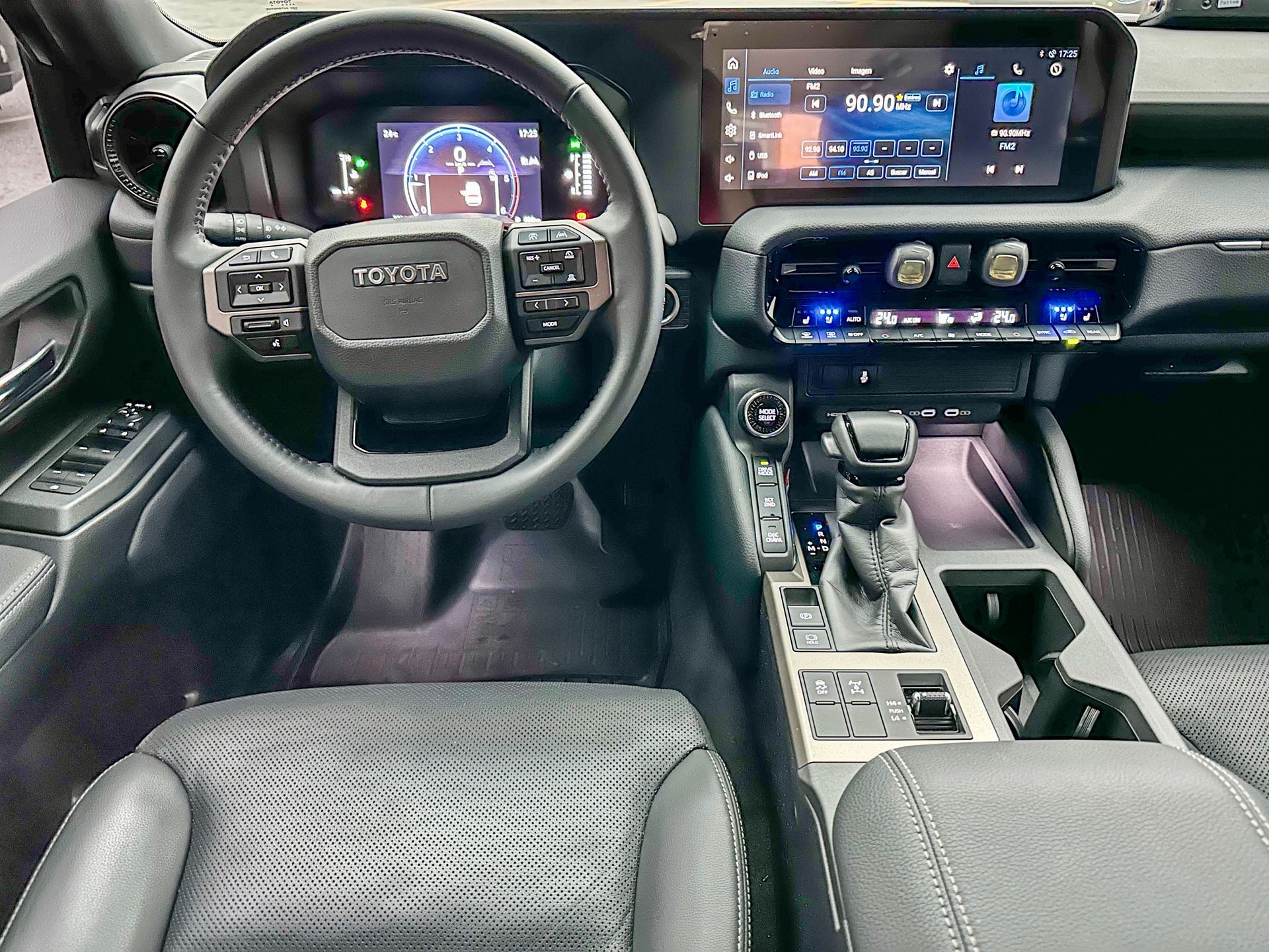 Interior del SUV Toyota con tablero digital, pantalla táctil central y asientos de cuero negro.