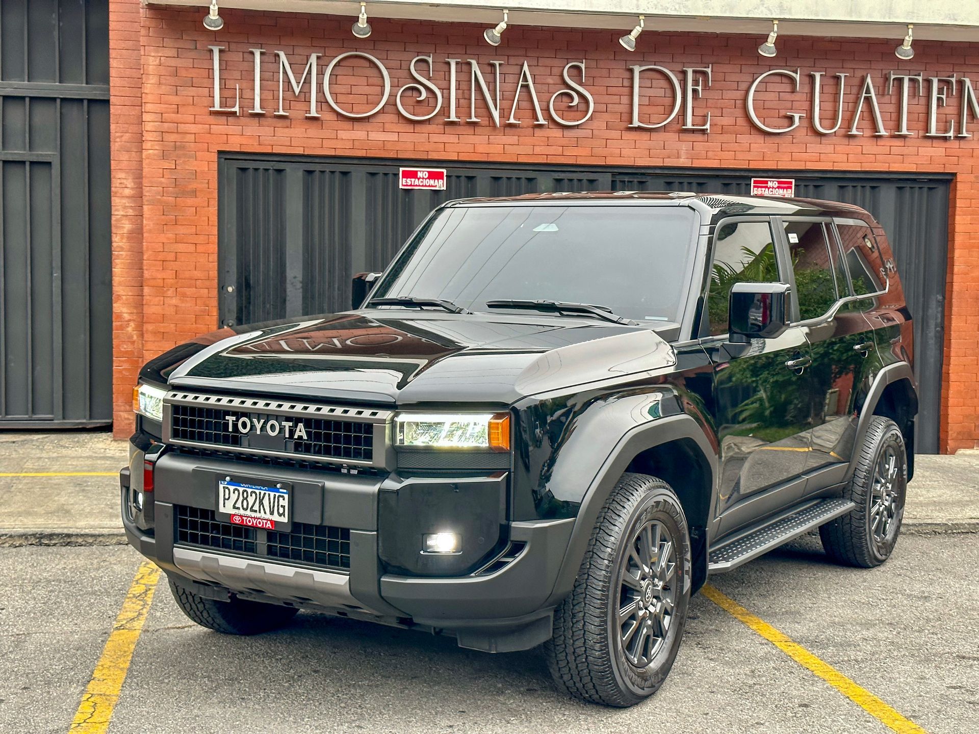 Camioneta Toyota negra estacionada frente a un edificio con letrero que dice “LIMOSINAS DE GUATEM…”.