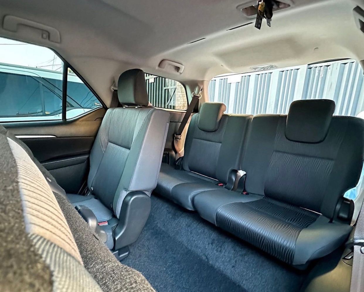Interior del coche con los asientos traseros abatidos y asientos delanteros de color beige