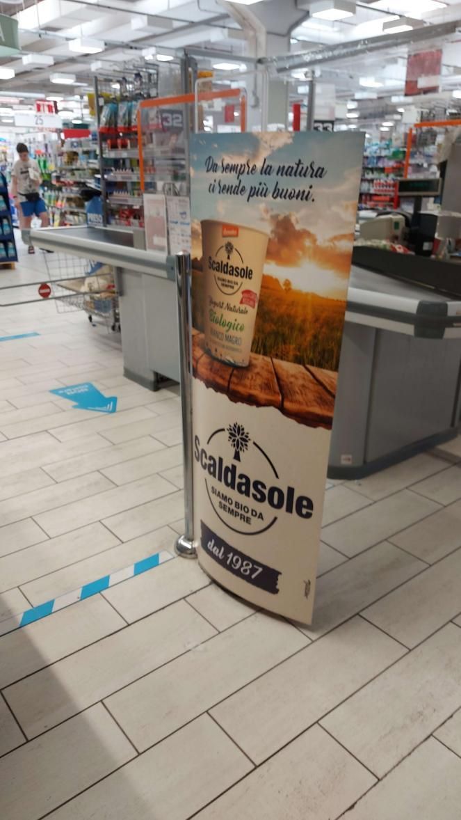 Corridoio del negozio con un espositore promozionale di Vitasole vicino alle casse