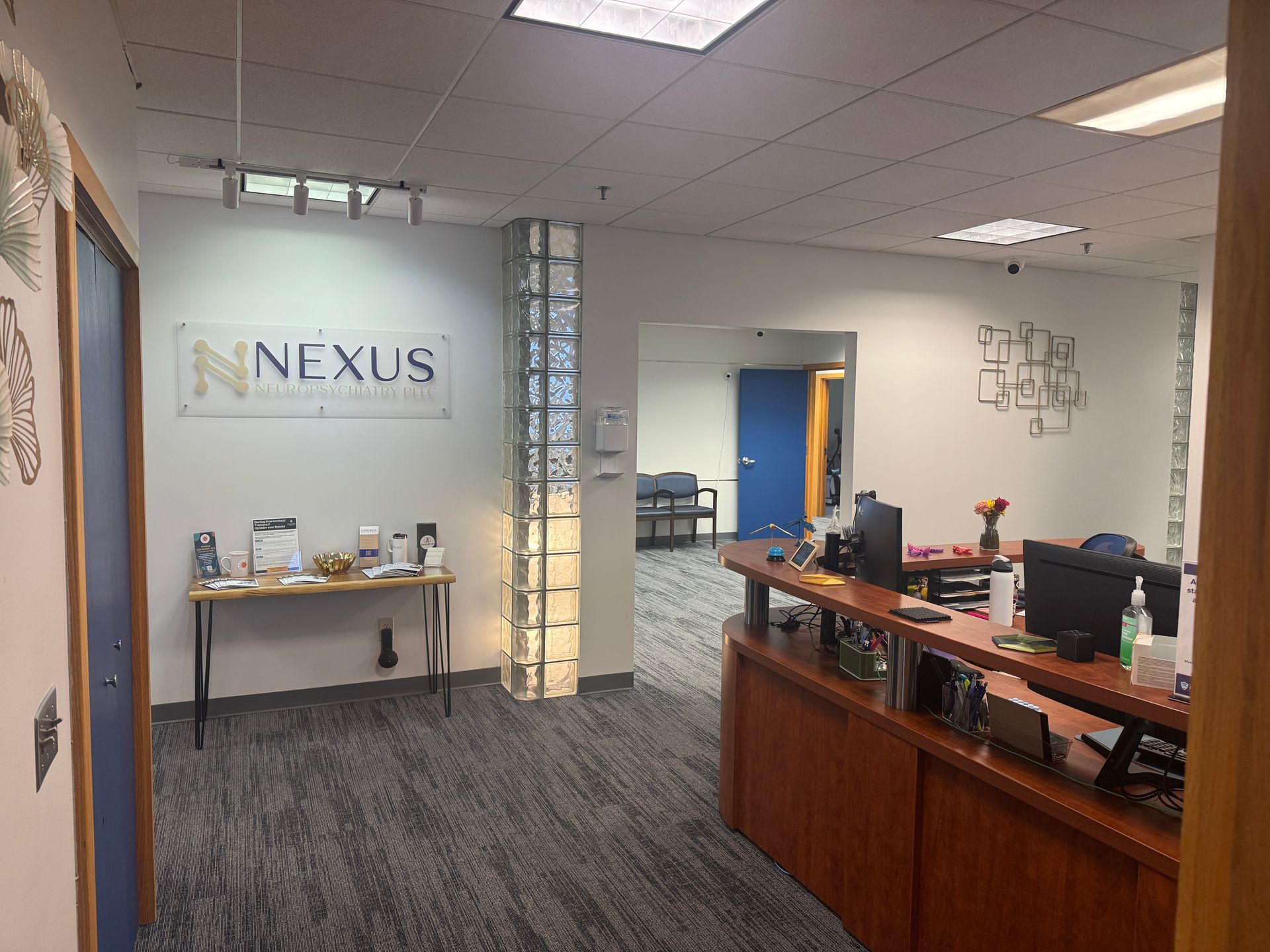 Office lobby with NFXUS sign, reception desk, and hallway opening.