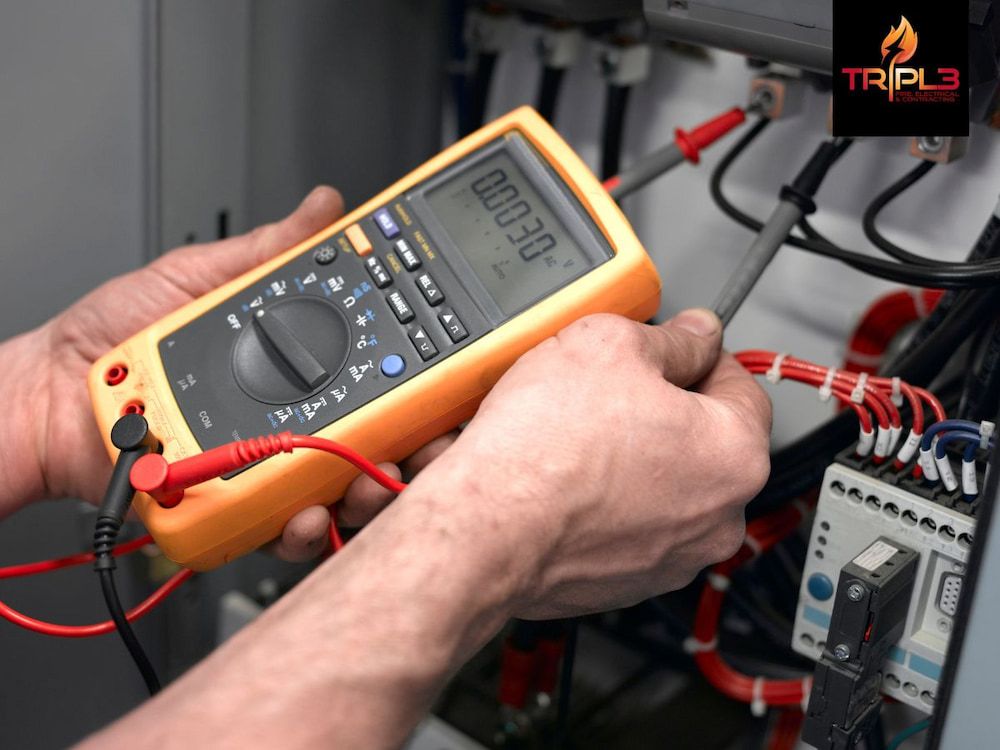 A Man is Holding a Fluke Multimeter in His Hands — Tr!pl3 Fire Electrical & Contracting in Alice Springs, NT