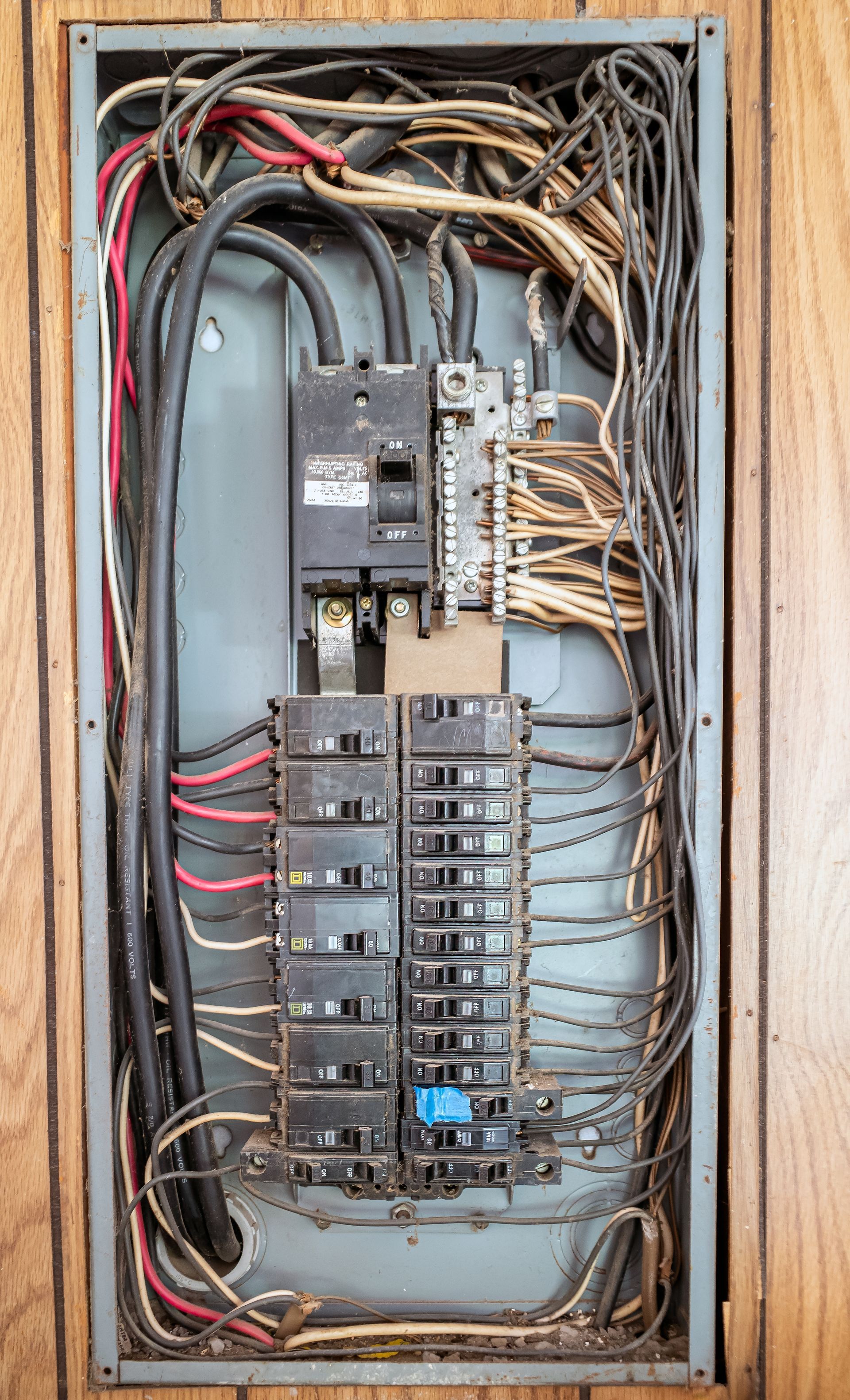 A very old electrical panel with a lot of wires coming out of it.