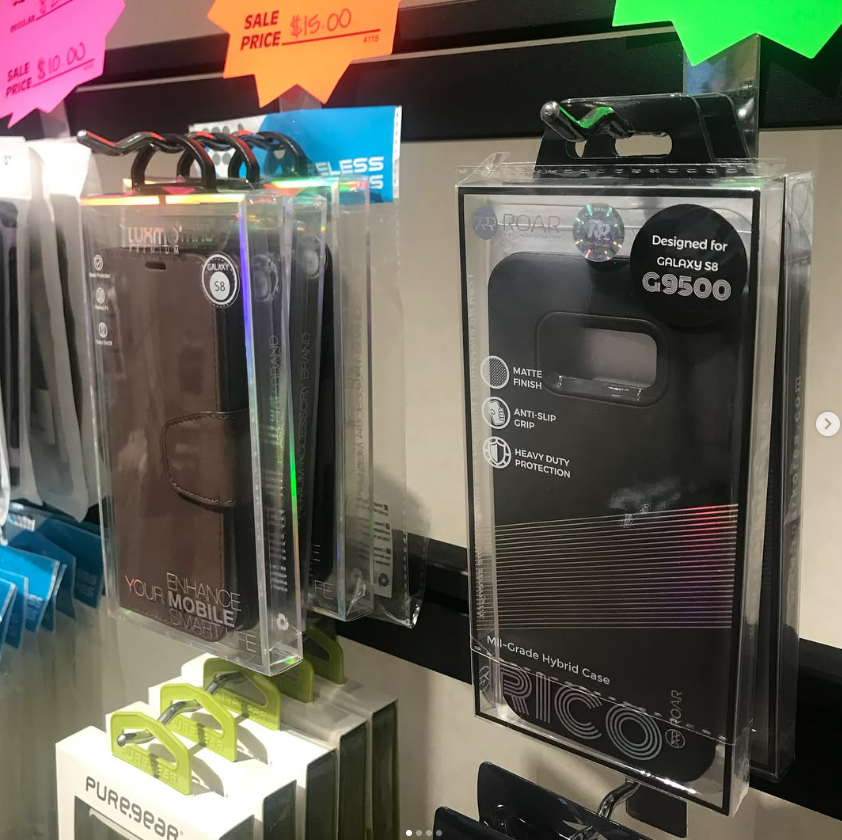 Retail display of phone accessories in clear plastic boxes, including a black C9500 package with price tags above.