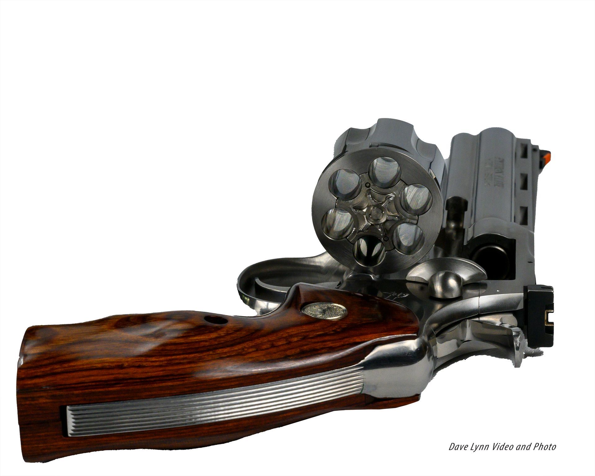 Wood-handled silver revolver with exposed cylinder on a white background
