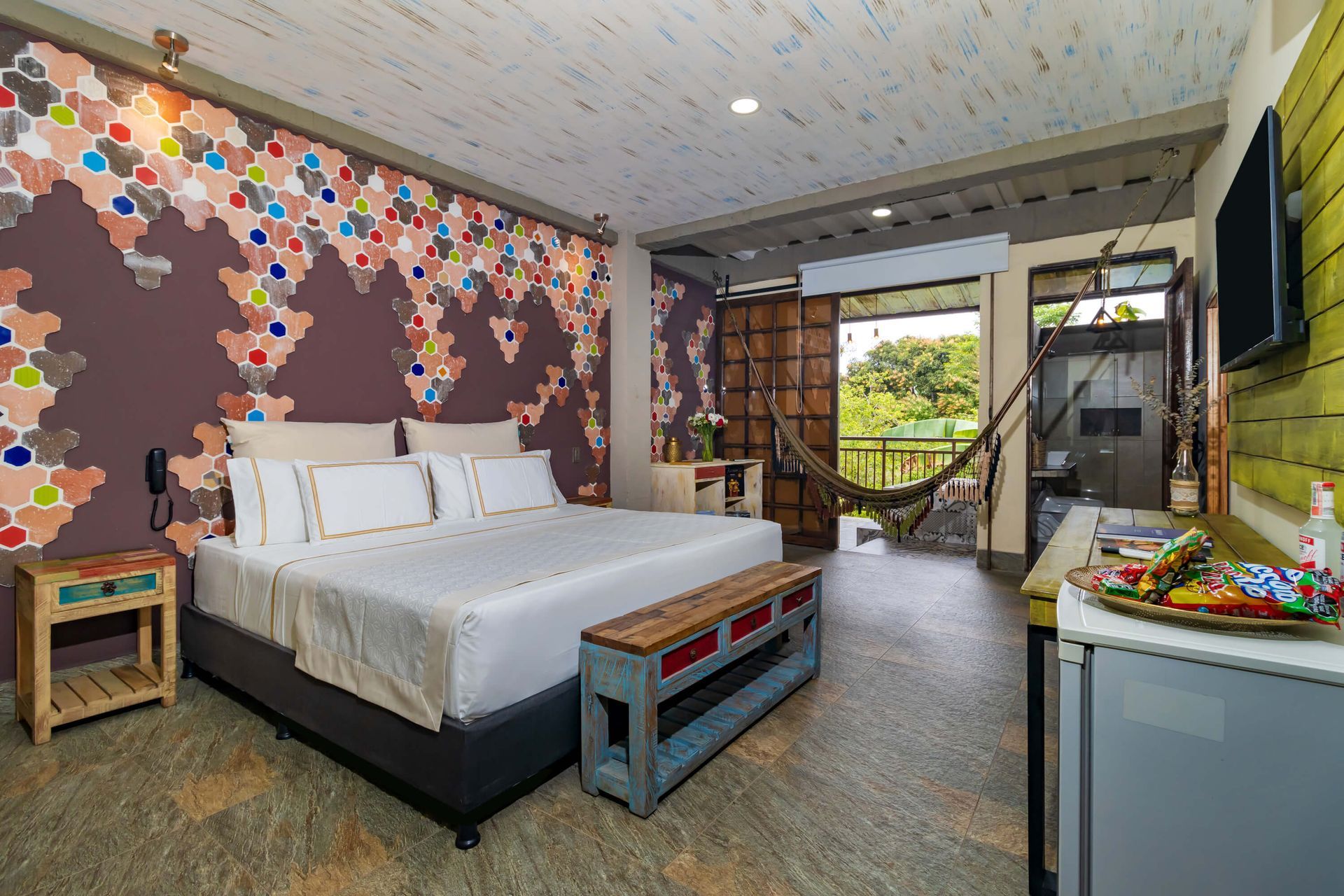 Hospédate en Villavicencio y disfruta de una habitación moderna con diseño colorido, cama cómoda y vista a la naturaleza.