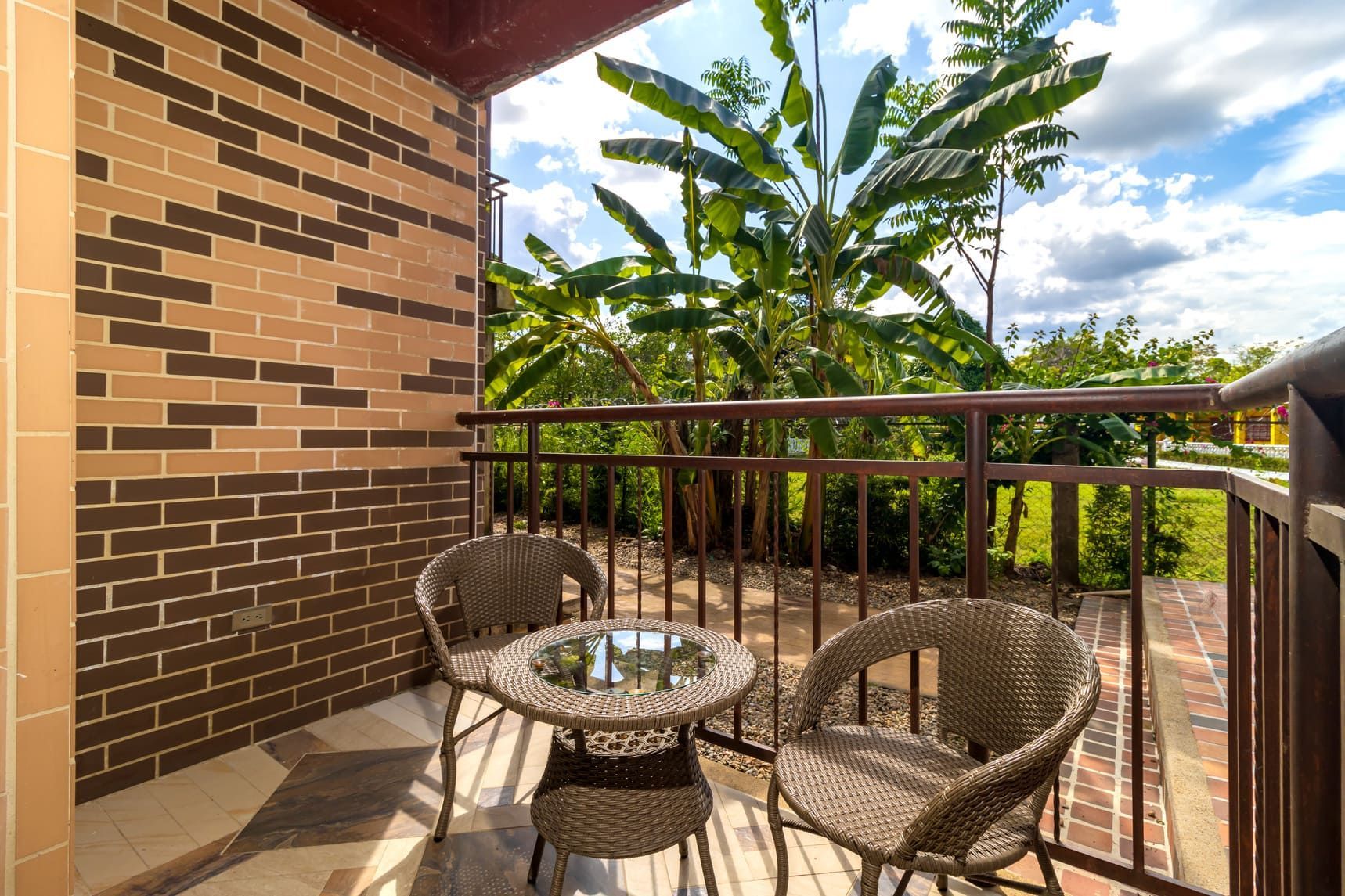 Terraza con mesas y sillas rodeada de vegetación en Villavicencio, ambiente tranquilo para compartir