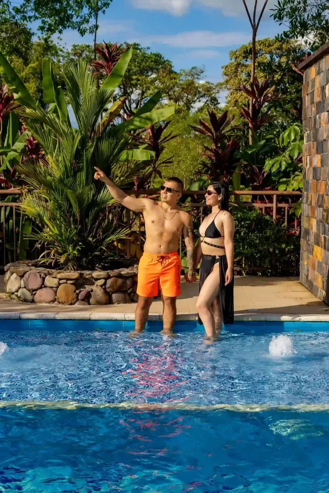 Pareja relajada en la piscina al aire libre de NQ Hotel Orinoquía Villavicencio, plan romántico con naturaleza y descanso.”
