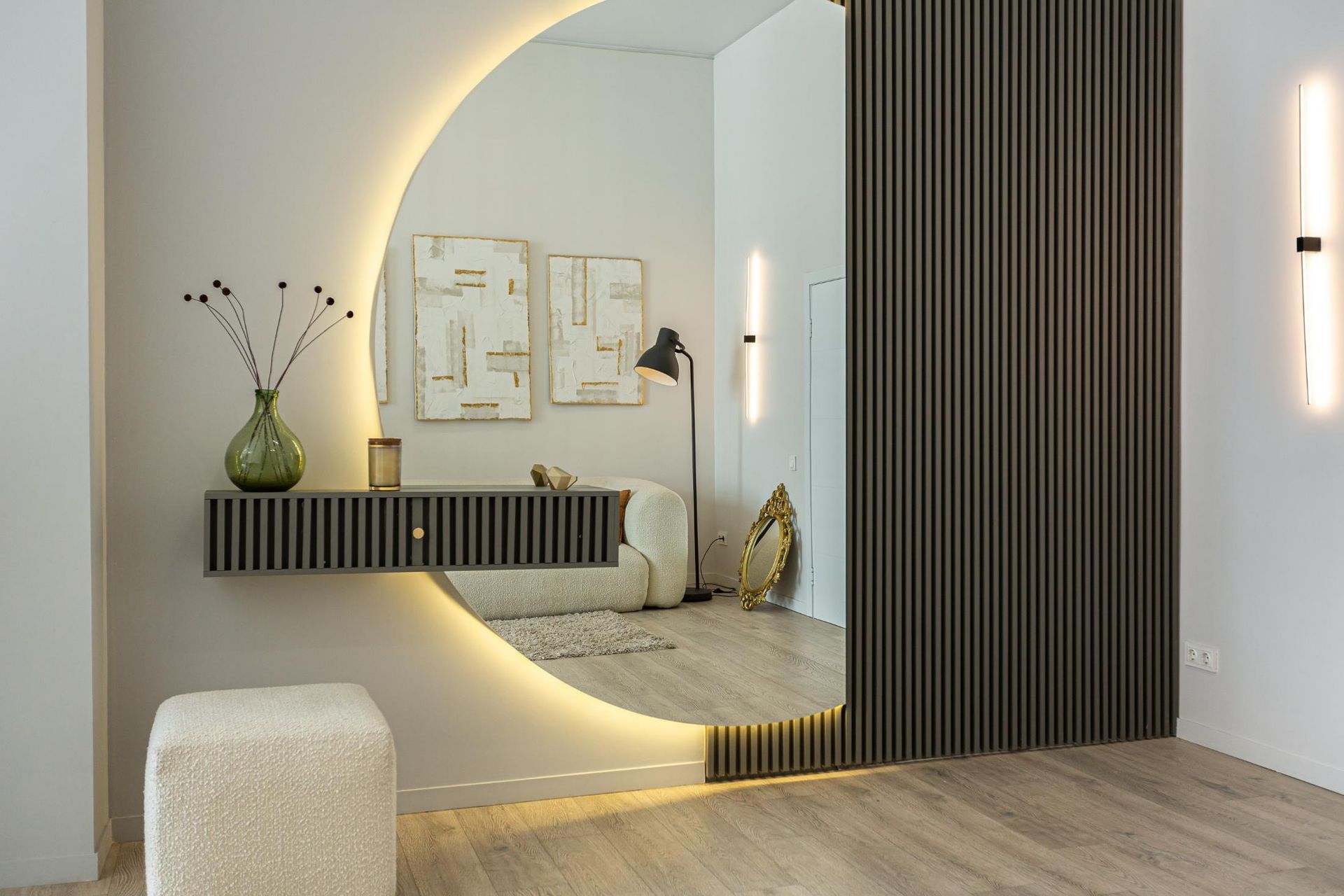 Minimalist room with round mirror, floating shelf, warm lighting, and wood slat wall