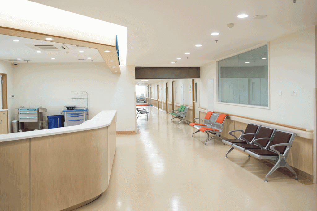 A hospital hallway with a reception desk and waiting chairs.