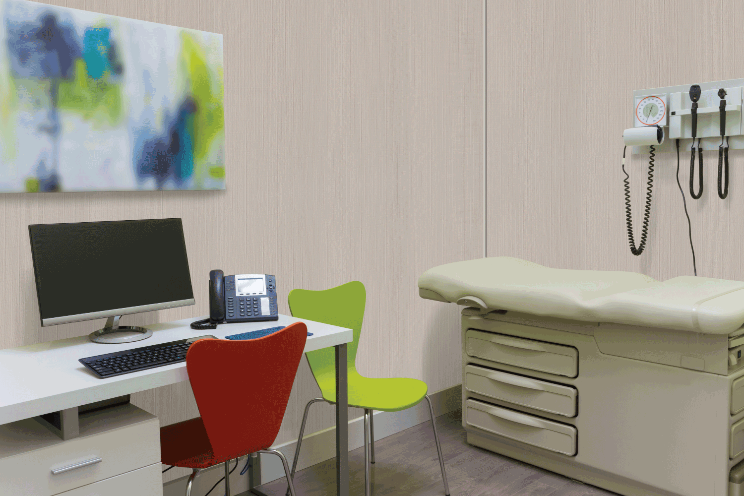 A doctor 's office with a desk and a bed