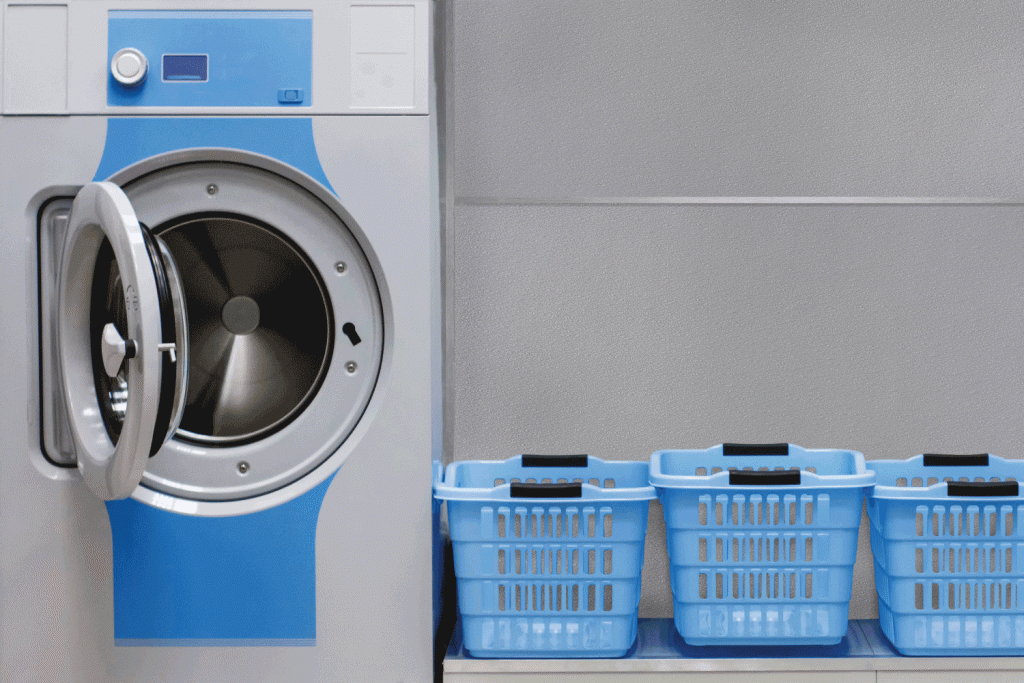A blue washing machine is next to a row of blue laundry baskets