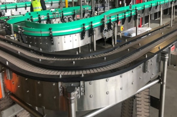 A conveyor belt is moving bottles in a factory.