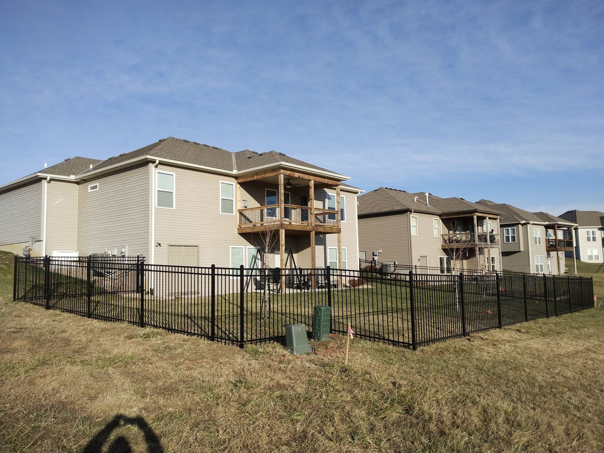 Apartment buildings with fenced yards under a clear blue sky