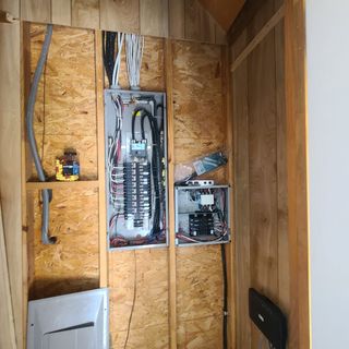 A wooden wall with electrical panels on it