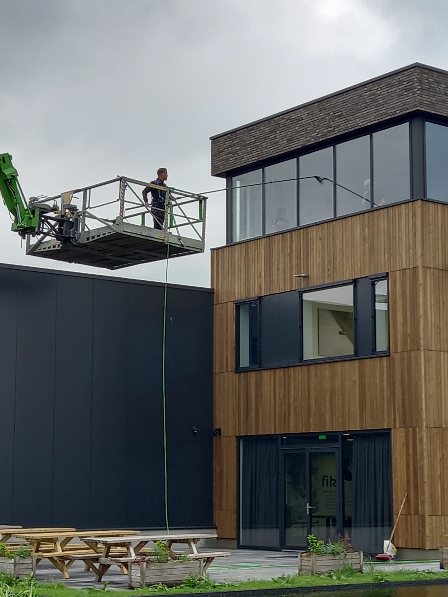 Een man staat op een lift voor een gebouw.