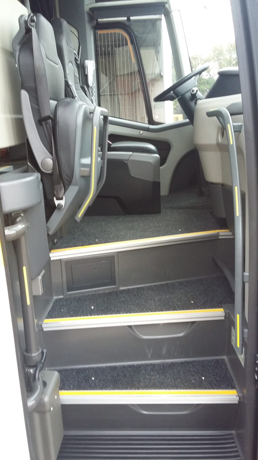 De binnenkant van een bus met trappen die naar de stoelen leiden.
