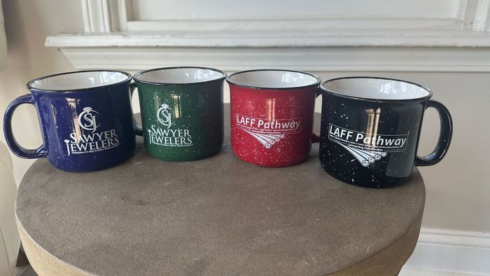 Four coffee mugs are sitting on top of a table.