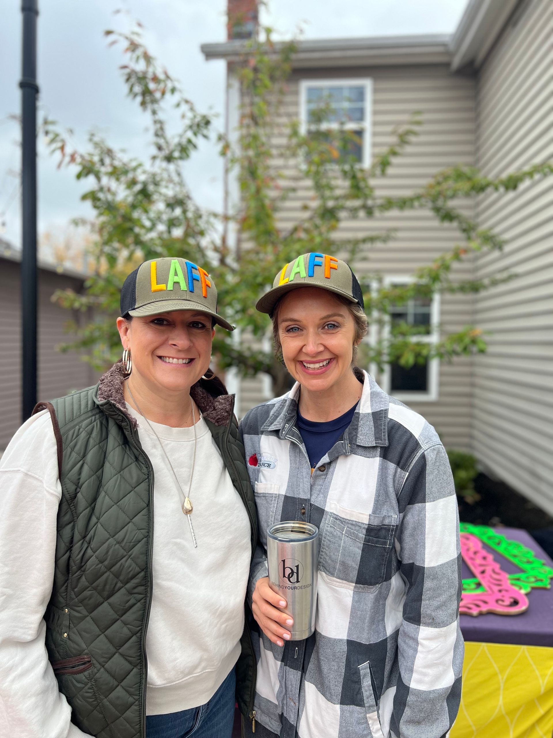 Two women wearing hats are standing next to each other