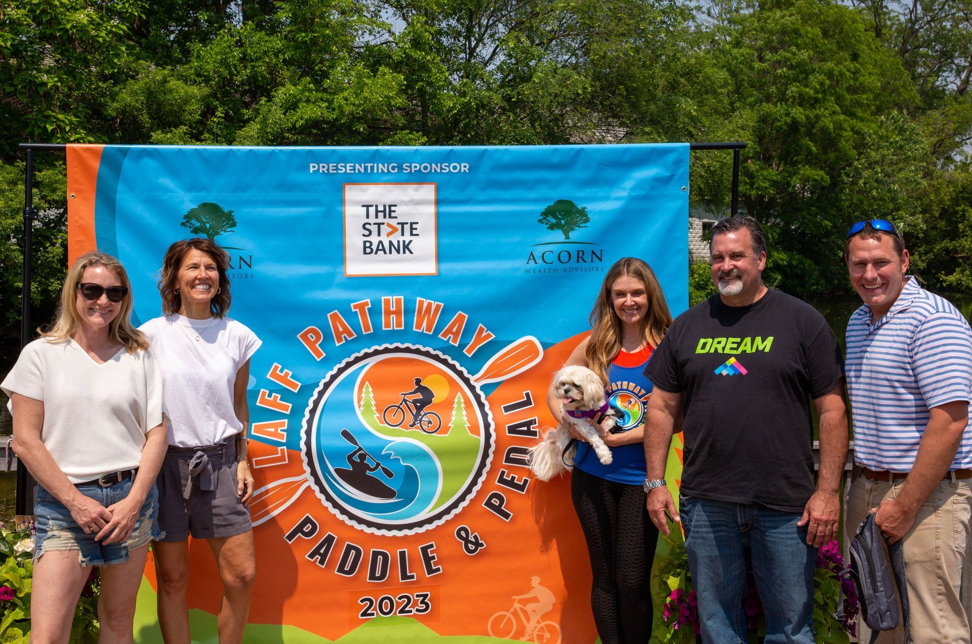 A group of people are posing for a picture in front of a banner.