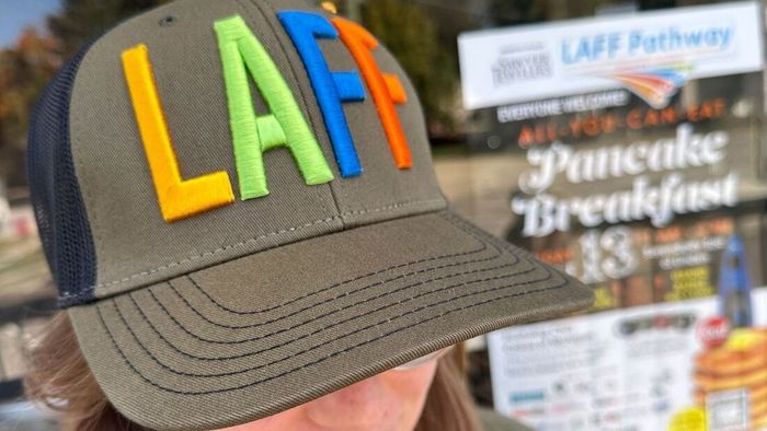 A person wearing a hat that says laff on it
