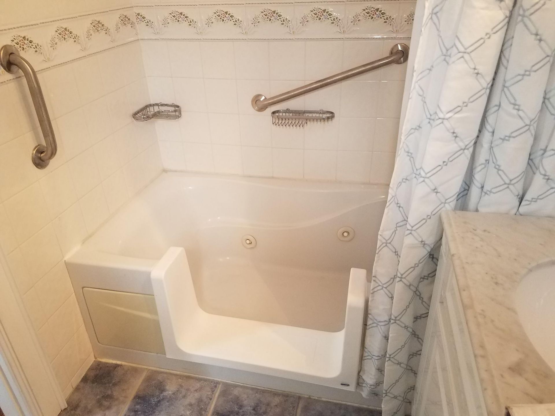 Accessible bathroom with a step-in bathtub, grab bars, and a shower curtain.