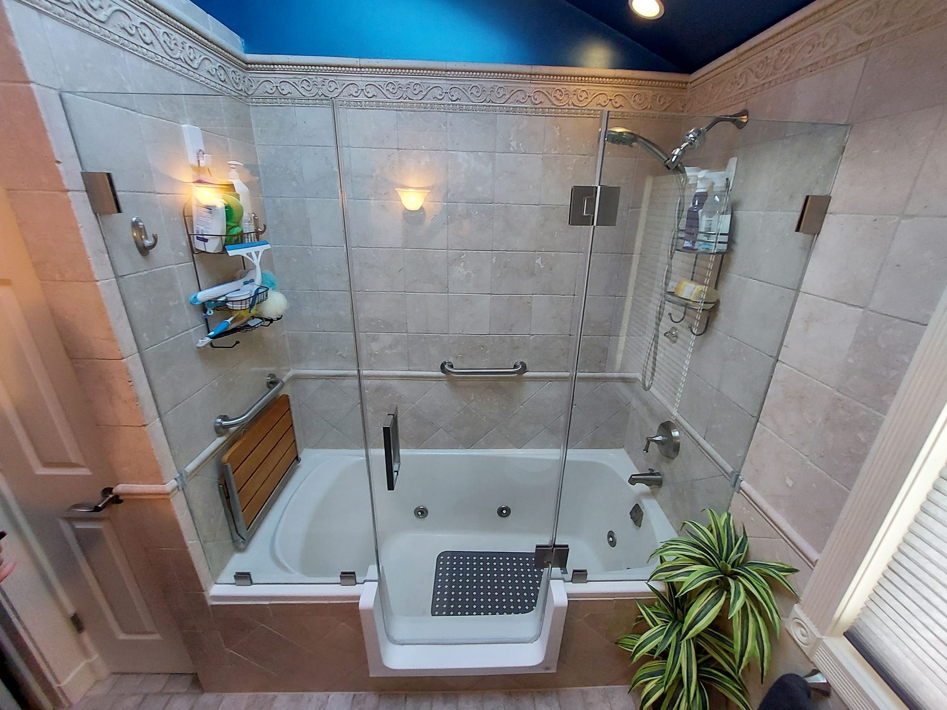 Accessible bathroom with step-in tub, beige tile walls, and safety grab bars
