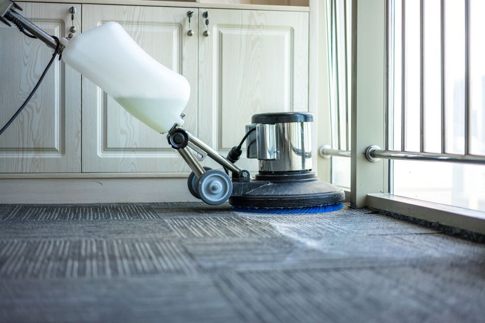 A Vacuum Cleaner is Cleaning a Carpet in a Kitchen — Doobies Cleaning Service in Port Macquarie, NSW
