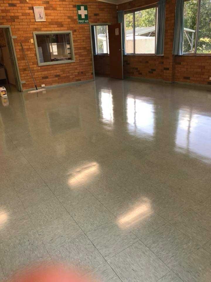 A Large Room With a Brick Wall and a Tiled Floor — Doobies Cleaning Service in Kempsey, NSW