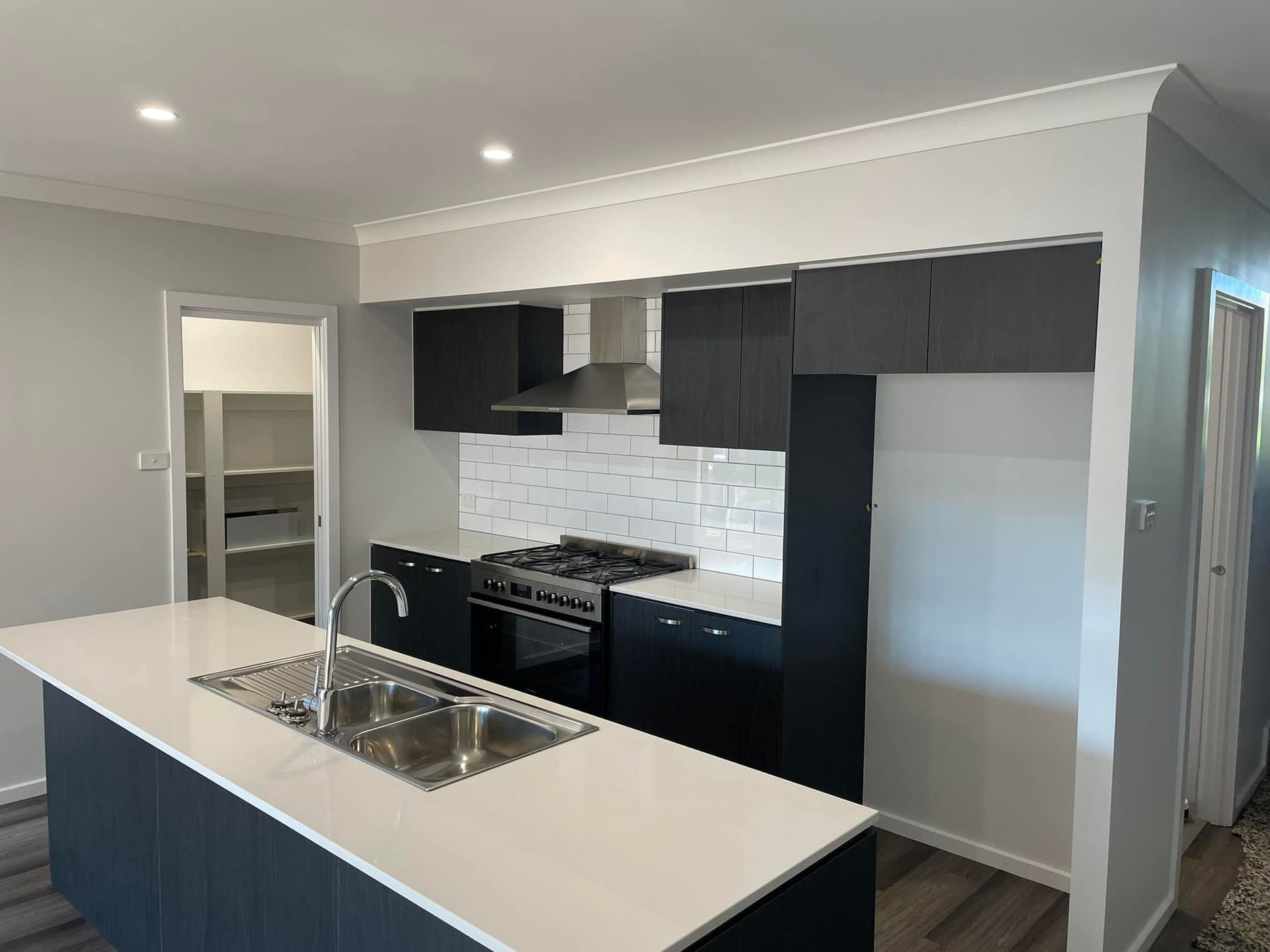 A Kitchen With Black Cabinets and White Counter Tops — Doobies Cleaning Service in Port Macquarie, NSW