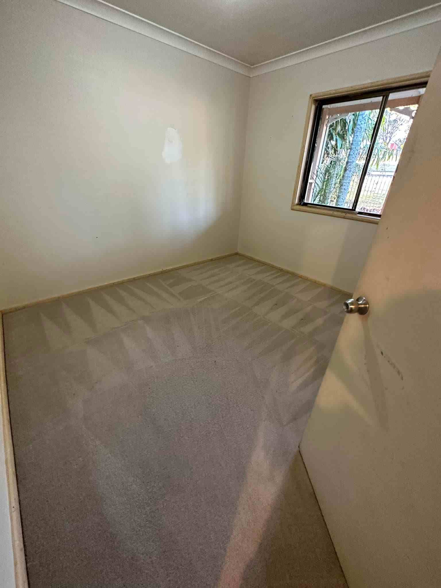 An Empty Bedroom With a Carpeted Floor and a Window — Doobies Cleaning Service in Kempsey, NSW