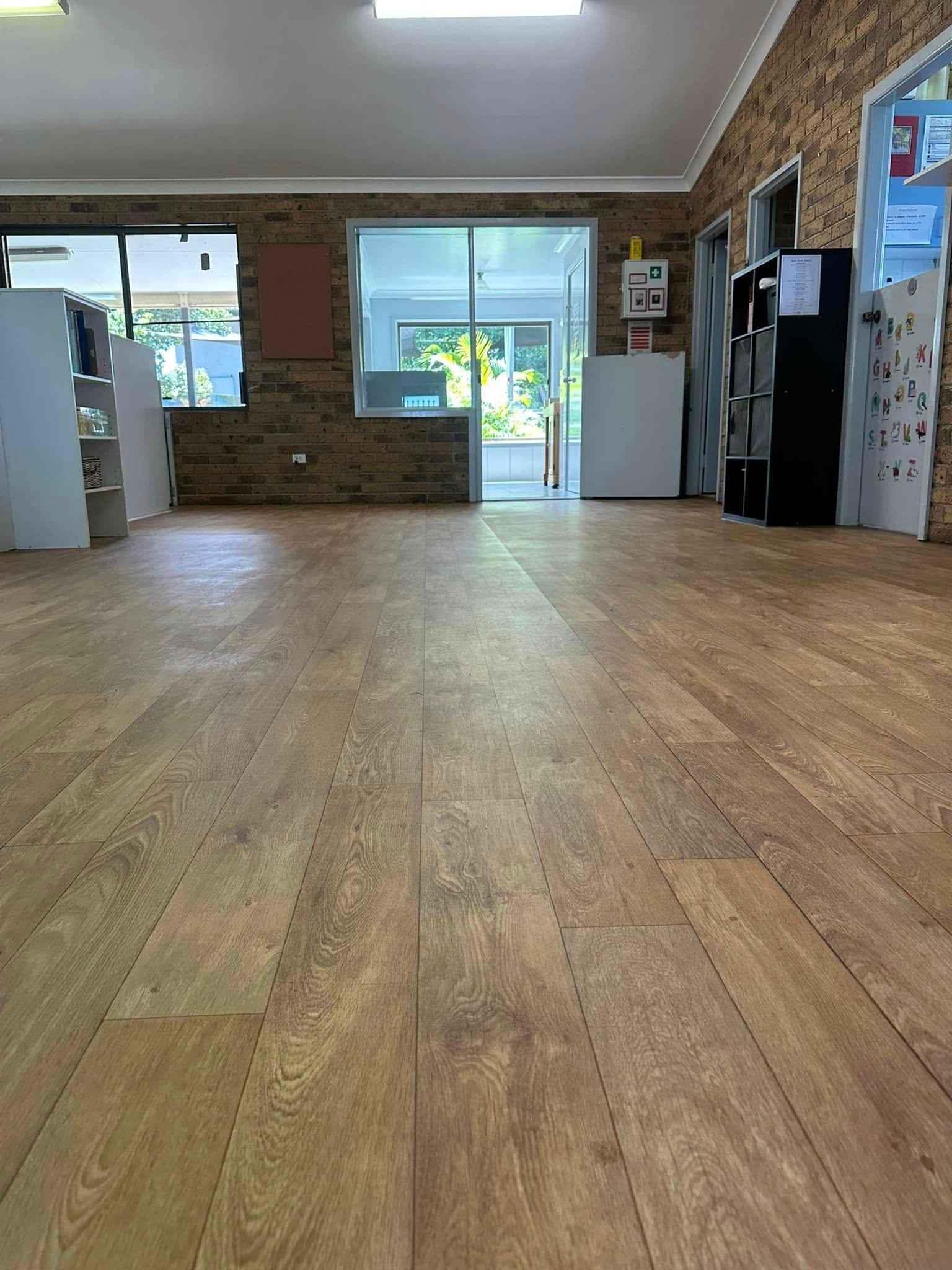 A Large Room With a Wooden Floor and a Brick Wall — Doobies Cleaning Service in Port Macquarie, NSW