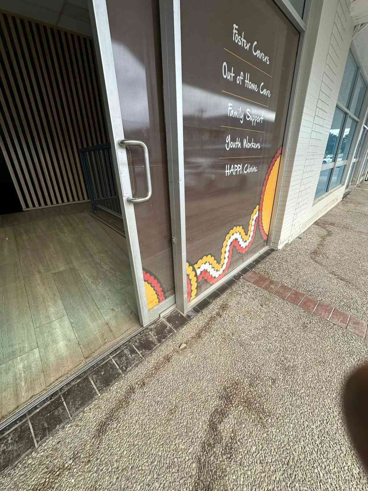 A Person is Standing in Front of a Glass Door With a Sign on It — Doobies Cleaning Service in Port Macquarie, NSW