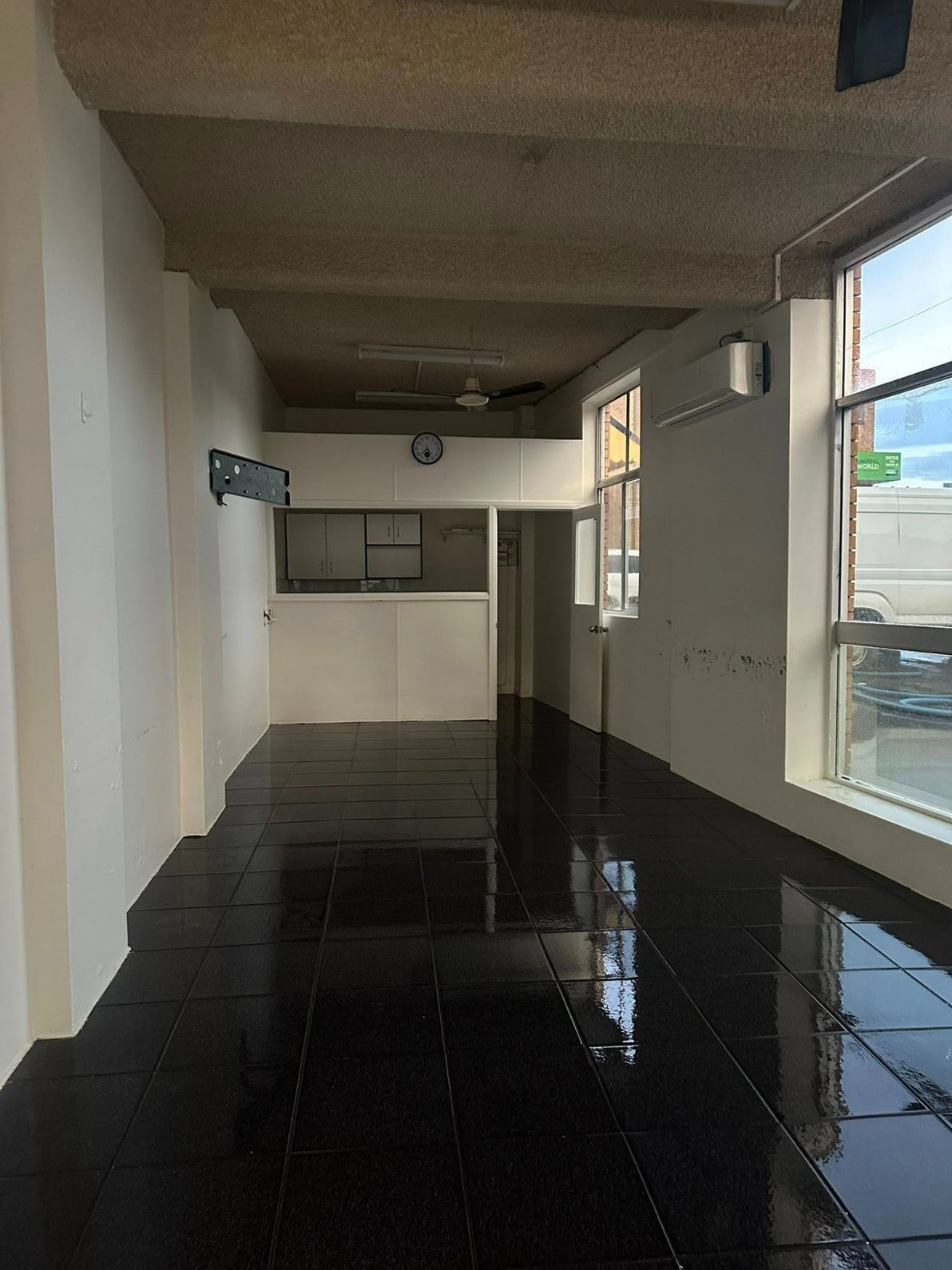 An Empty Room With a Black Tile Floor and White Walls — Doobies Cleaning Service in Port Macquarie, NSW
