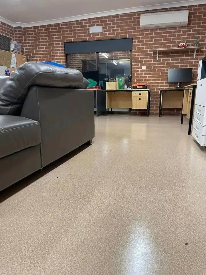 A Living Room With a Couch , Desk , Computer and a Brick Wall — Doobies Cleaning Service in Port Macquarie, NSW