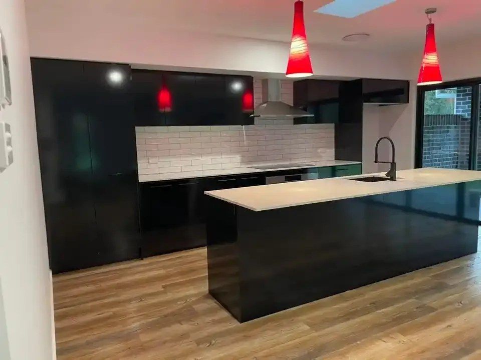 A Kitchen With Black Cabinets and a Large Island — Doobies Cleaning Service in Port Macquarie, NSW
