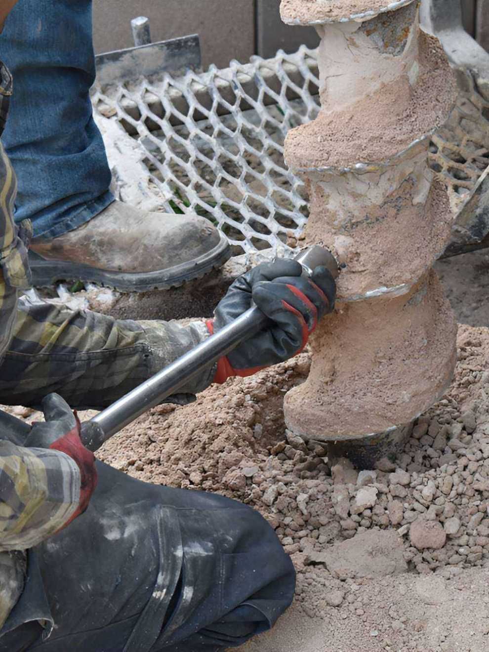 A Person Is Using A Wrench To Drill A Hole In The Ground — GEO – AM Consulting In Lismore, NSW