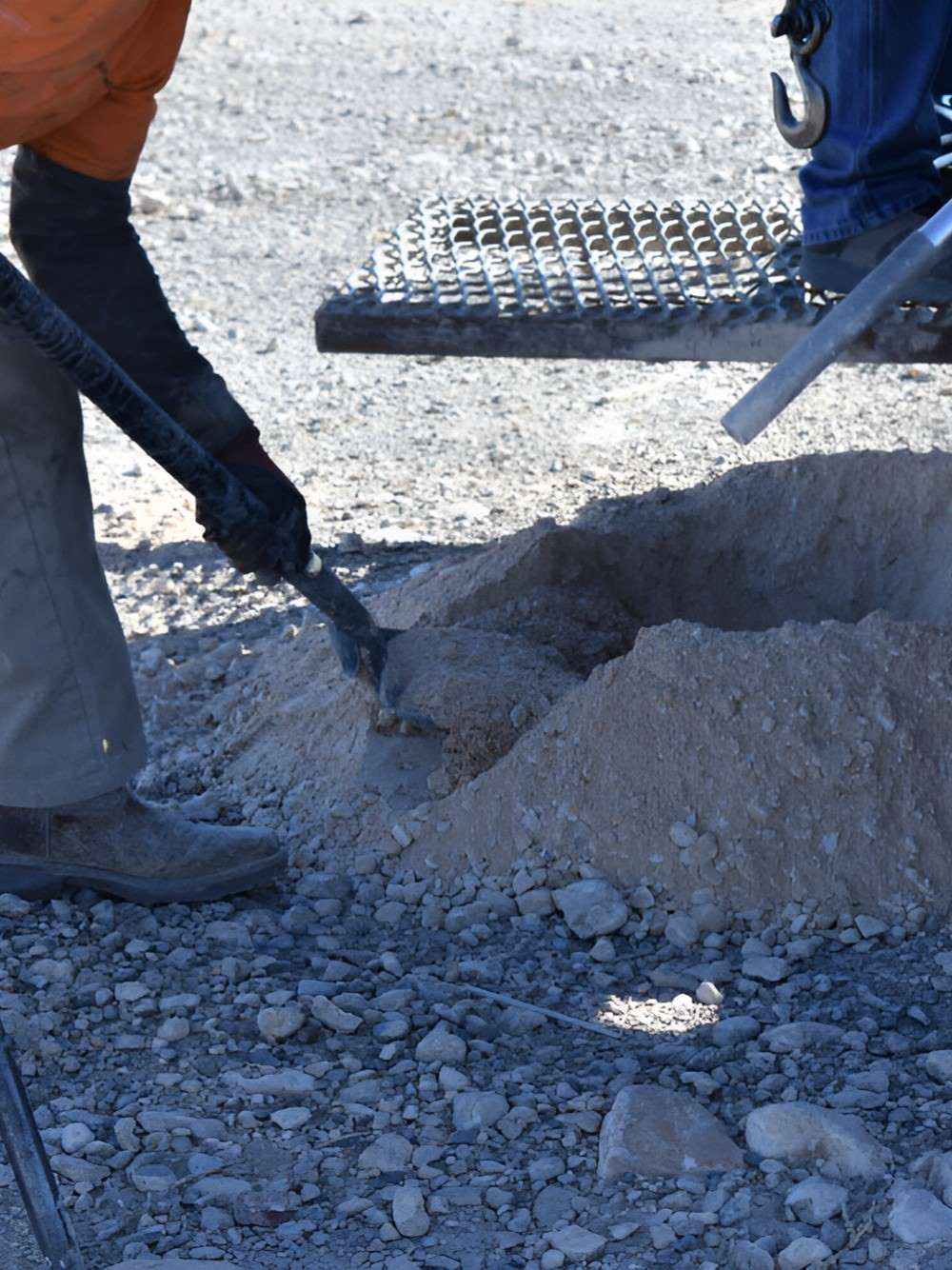 A Man Is Digging A Hole In The Ground With A Shovel — GEO – AM Consulting In Lismore, NSW