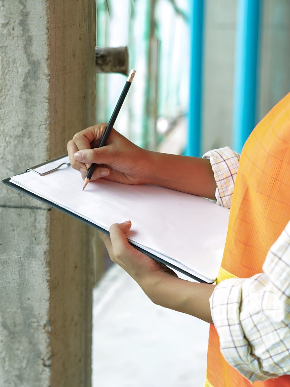 A Person Is Writing On A Clipboard With A Pencil — GEO – AM Consulting In Lismore, NSW