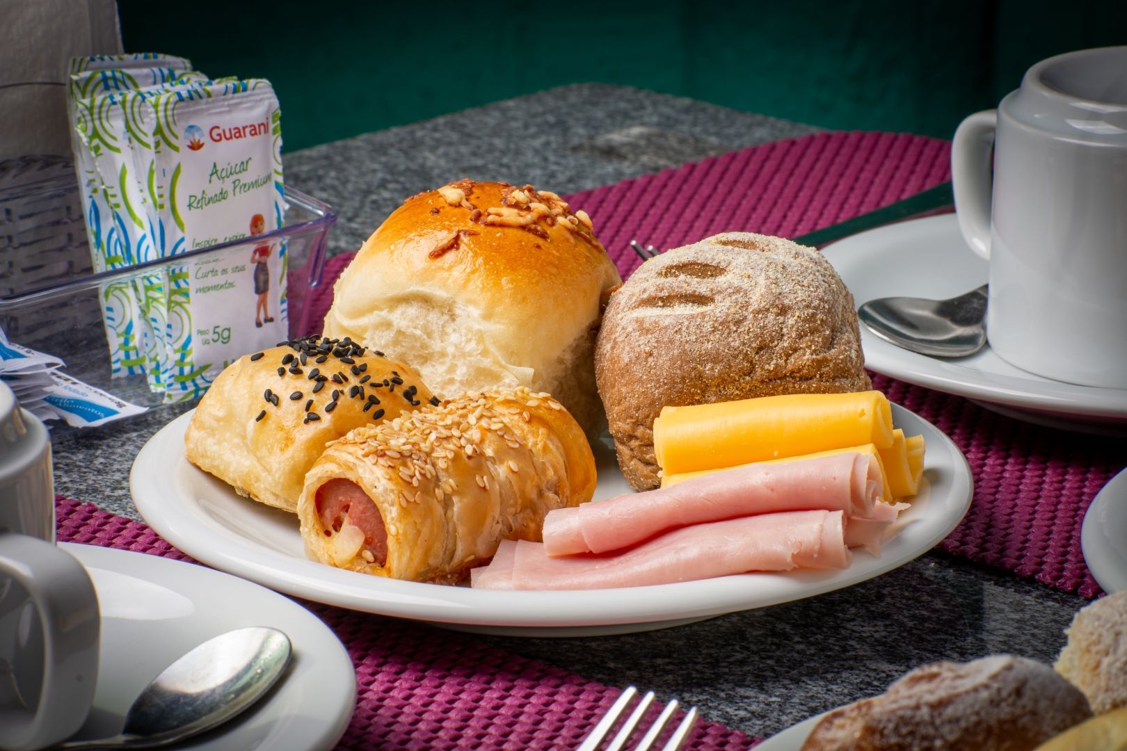Um prato de comida com presunto e queijo sobre uma mesa.