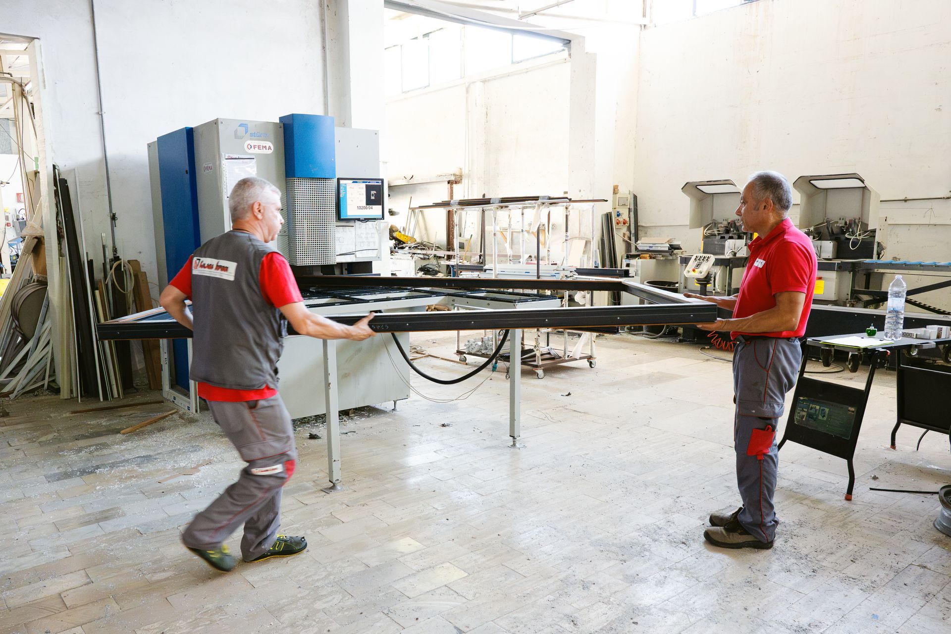 Due uomini stanno lavorando a una macchina in una fabbrica.