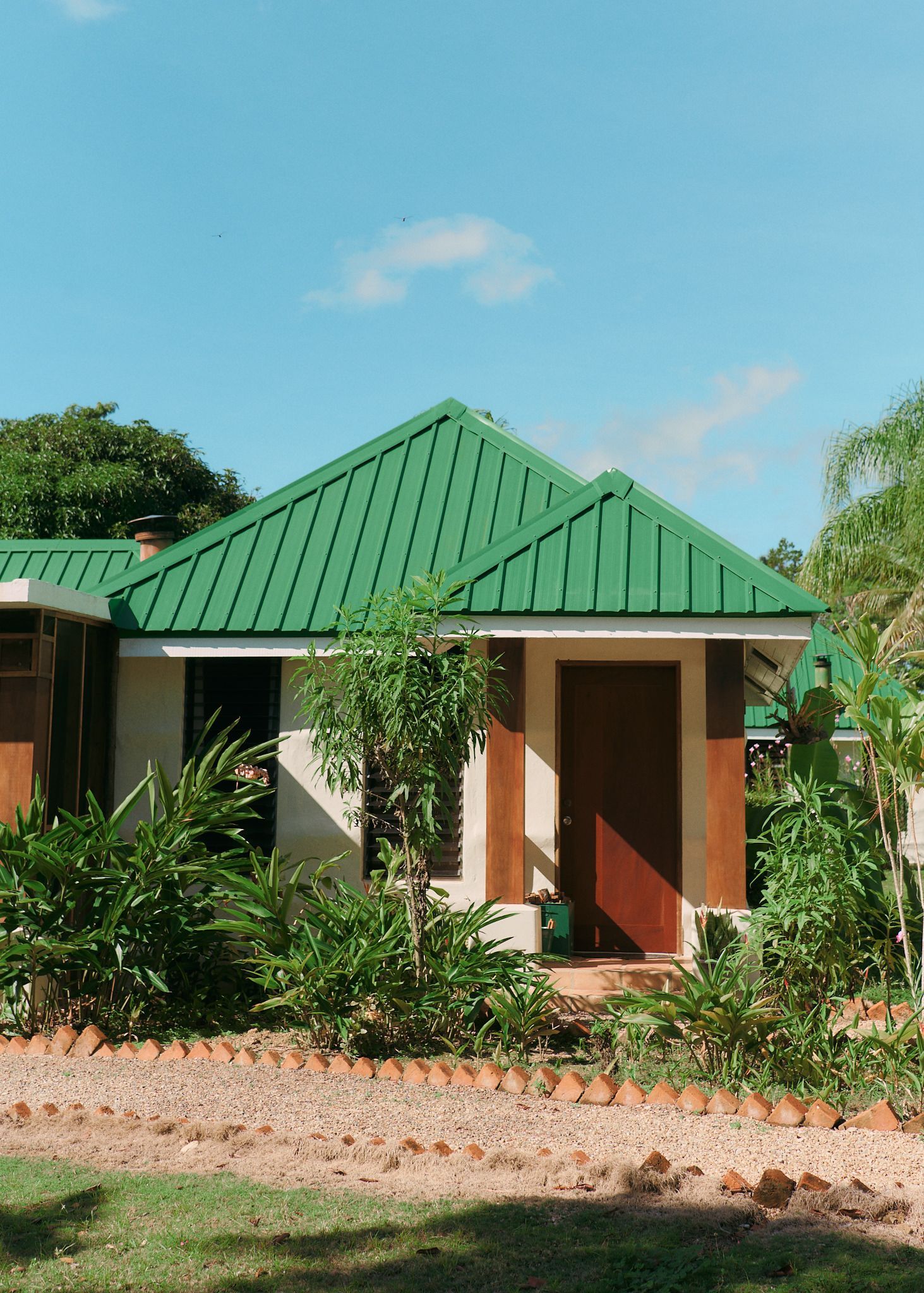 a small white house with a green roof