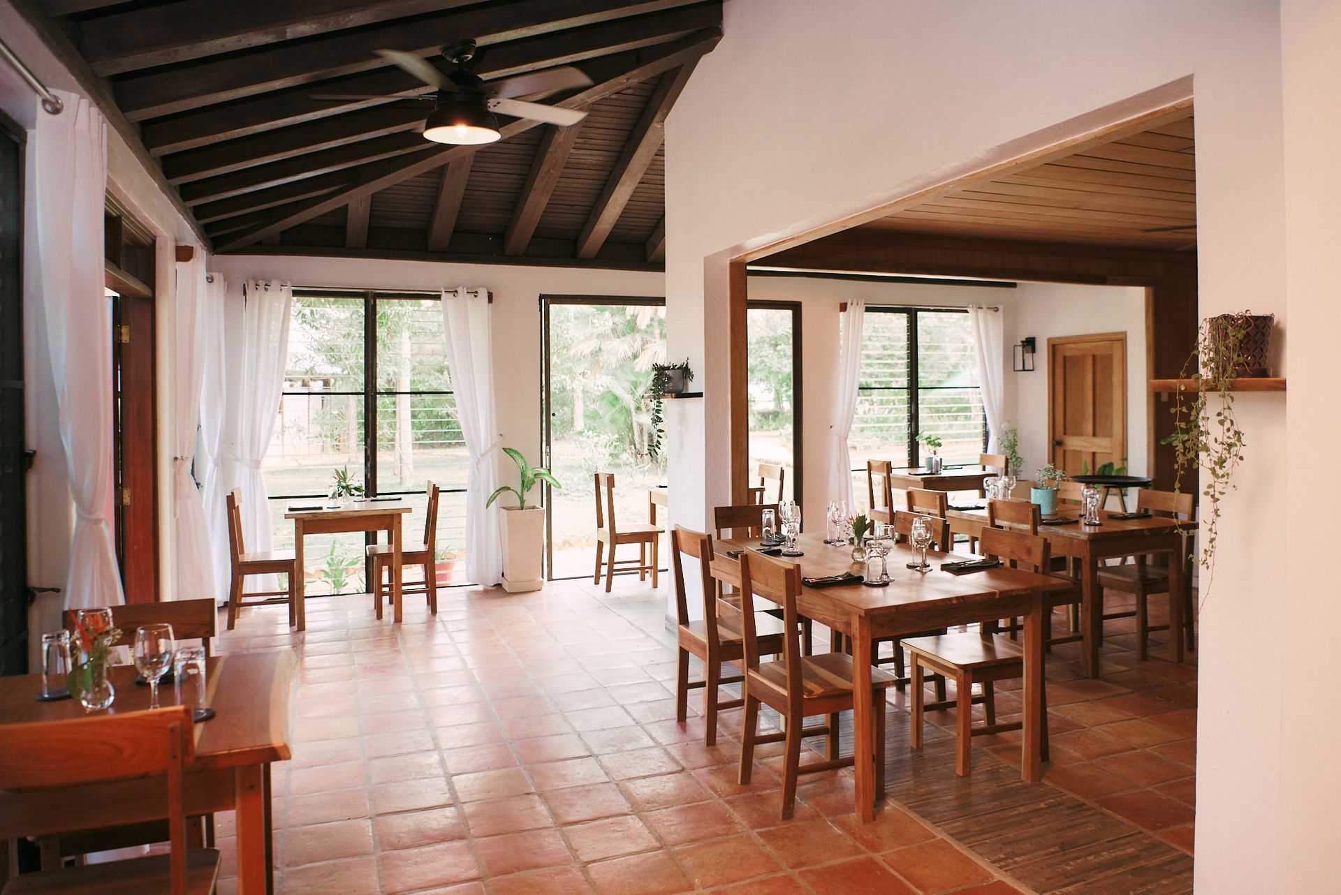a large dining room with tables and chairs and a ceiling fan .