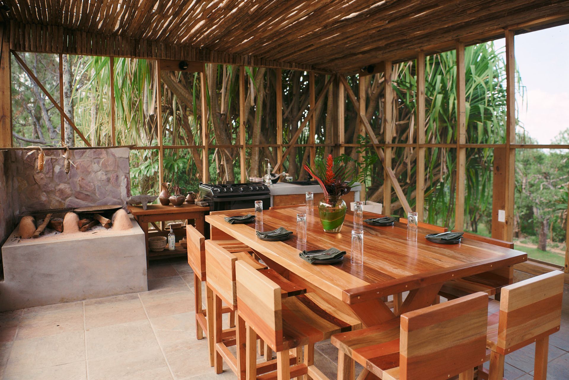 a wooden table and chairs in a room with a bamboo roof
