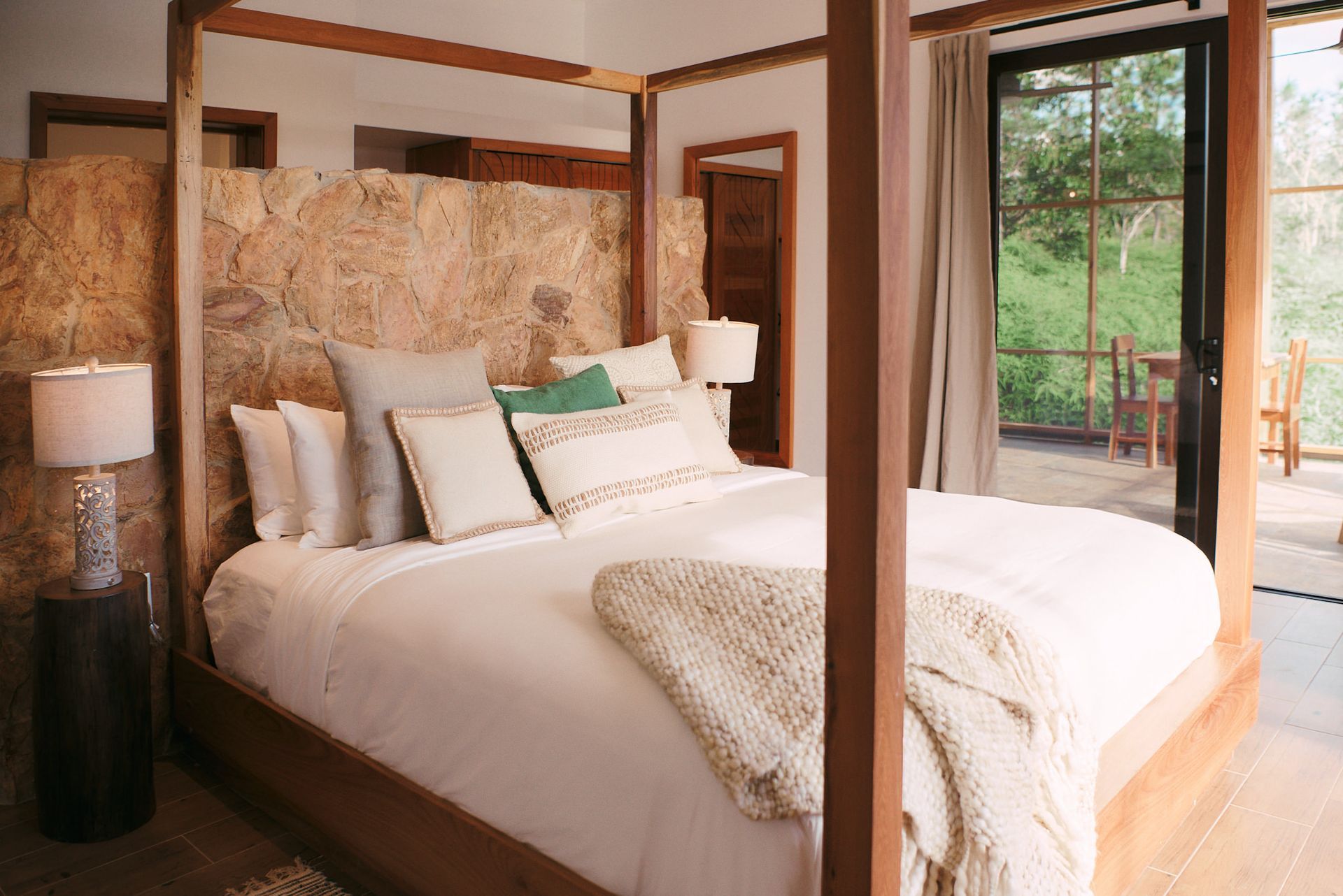 a bedroom with a four poster bed and a sliding glass door .